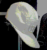A low-res white baseball cap hanging form an unidentified object.